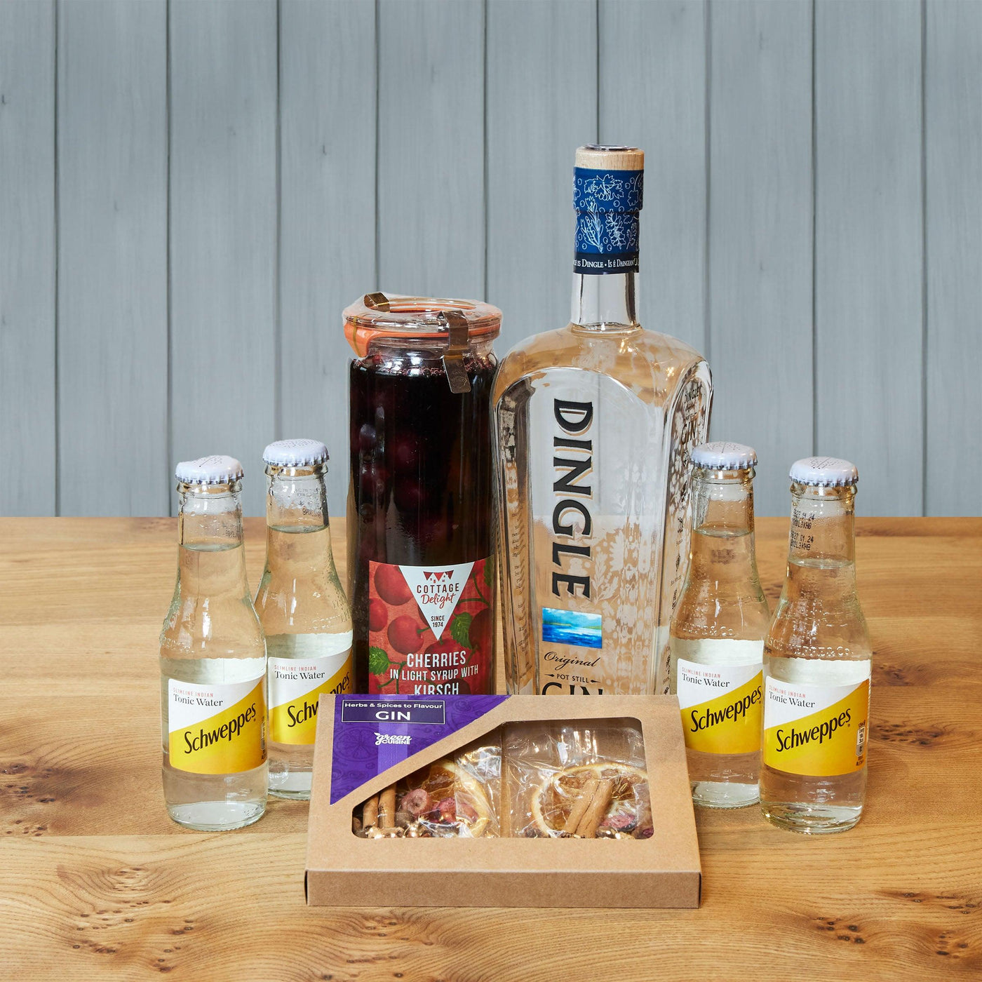 Hamper with a bottle of gin, a jar of cherries, four bottles of tonic water, and a box of herbs and flavours for gin.